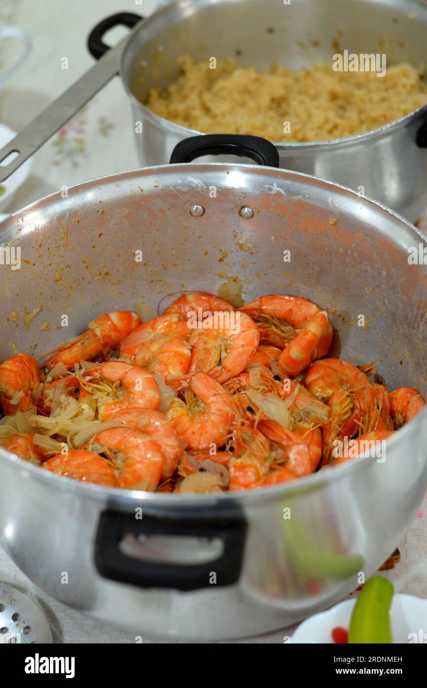 food table with Egyptian rice cooked on hot steam and cooked shrimps with cumin, lemon and onion, a crustacean (a form of shellfish) with an elongated Stock Photo