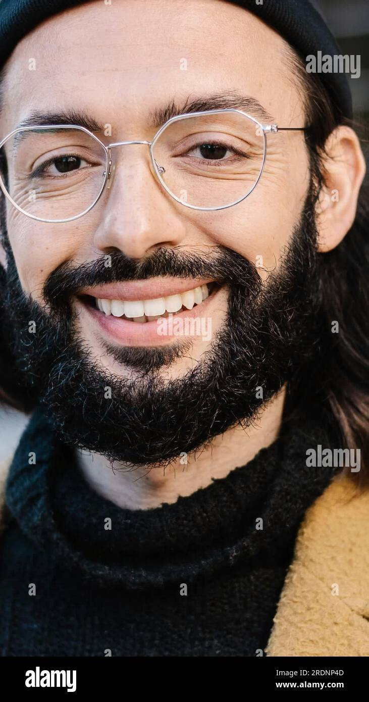 Portrait of positive young hipster man smiling at camera Stock Photo