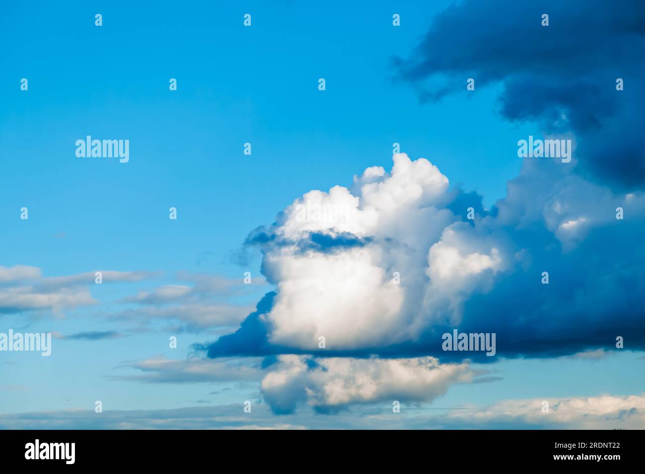 Sky background - white clouds on a bright blue sky gather into puffy clouds Stock Photo