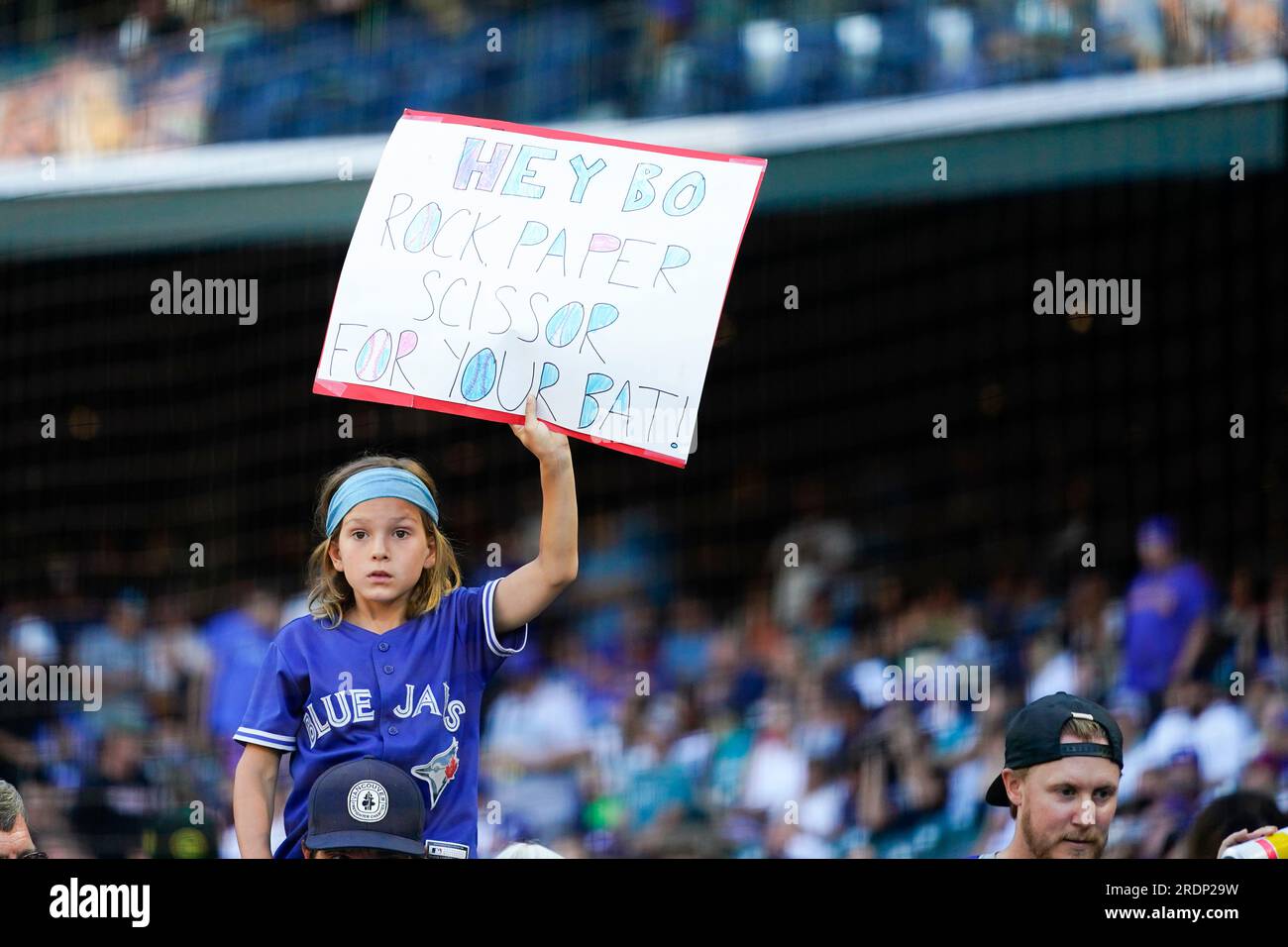 A fan wearing a Toronto Blue Jays jersey holds a sign for