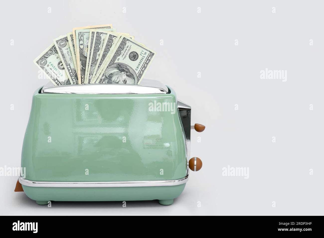 Toaster with dollar banknotes on light background Stock Photo - Alamy