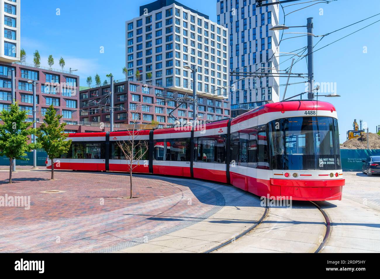 Toronto, Canada - July 19, 2023: Distillery District Loop. A modern Bombardier tramway or streetcar turns in the railroad tracks Stock Photo