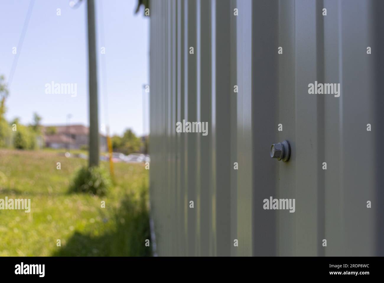 Gray metal fence with bolt - blurred background Stock Photo - Alamy