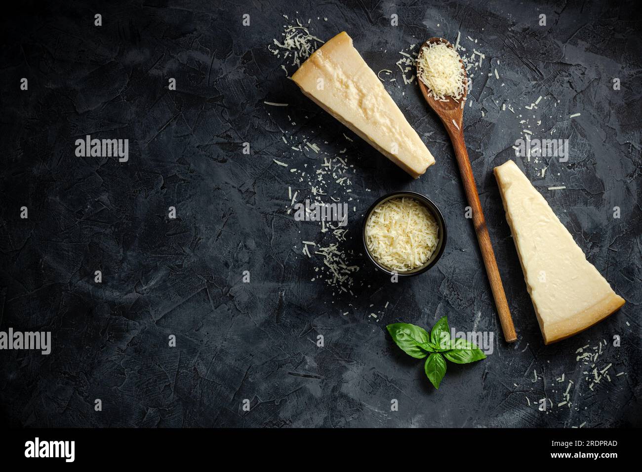 Set of hard cheeses with cheese knives on black stone background. Parmesan. Top view. Free space for your text. Stock Photo