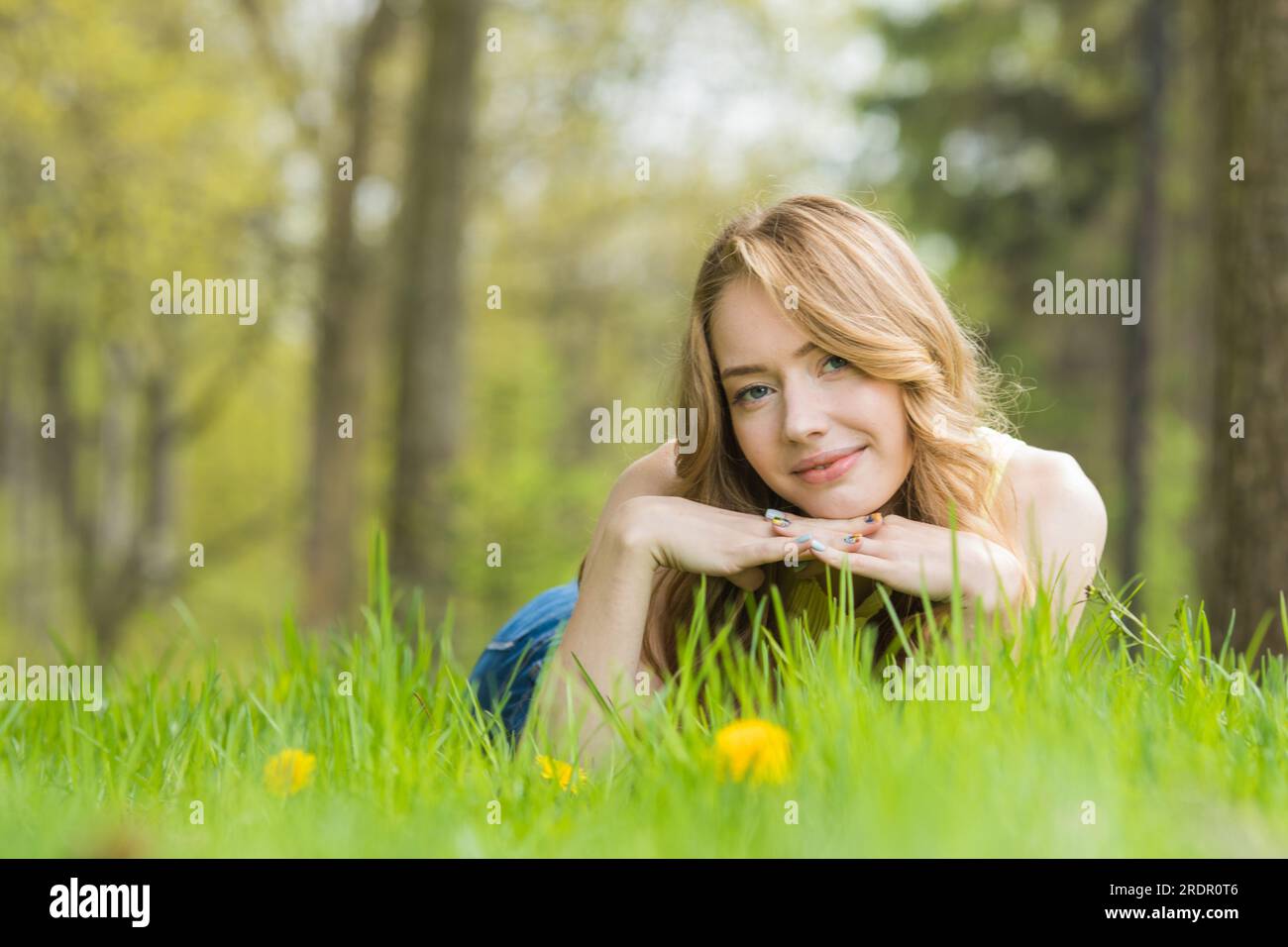 Pretty woman lying down on dandelions field happy cheerful girl resting ...
