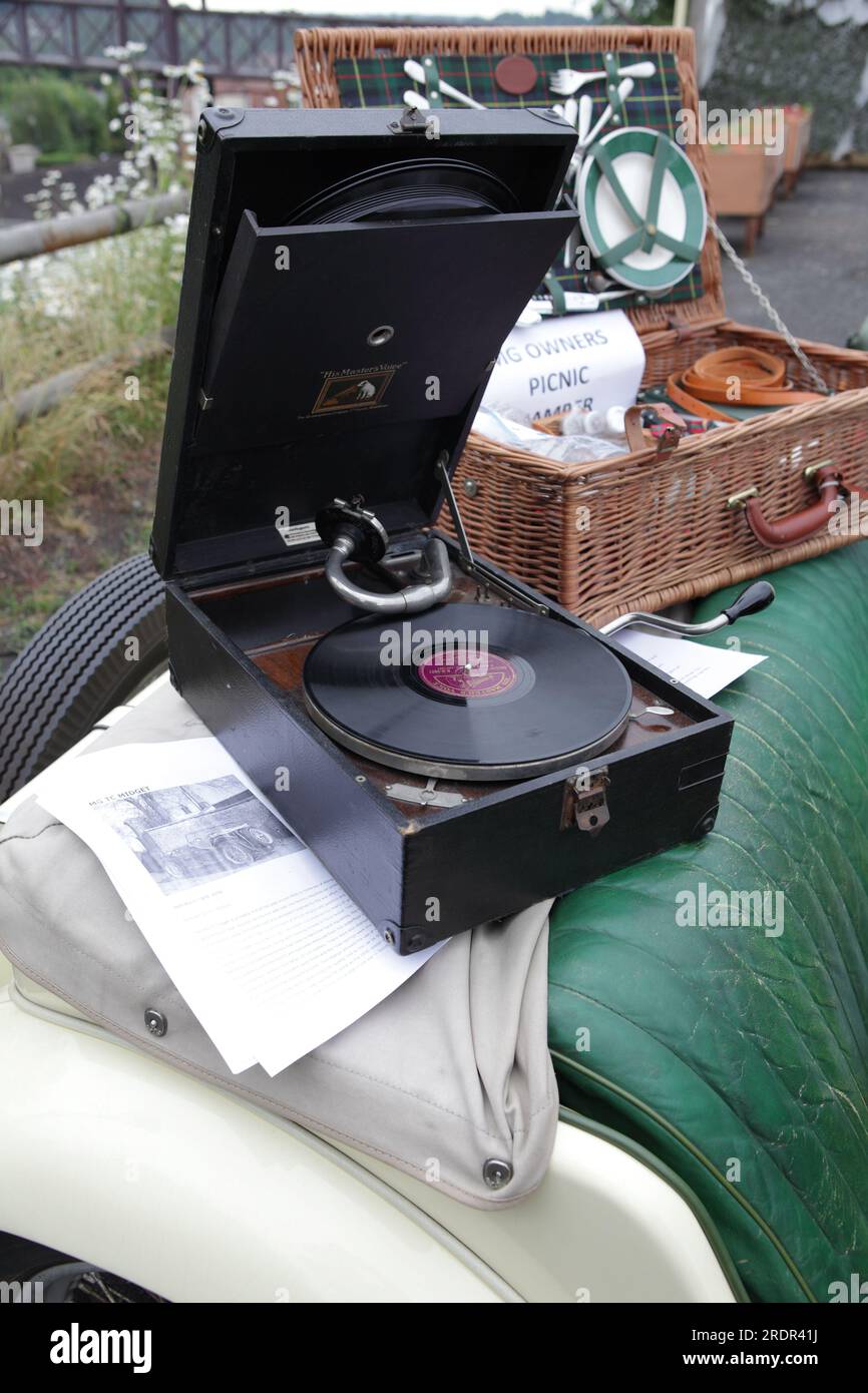 Two relics of the past in an Gramaphone and Picnic Basket, both resting upon an old MG TC10 rear seat. Stock Photo