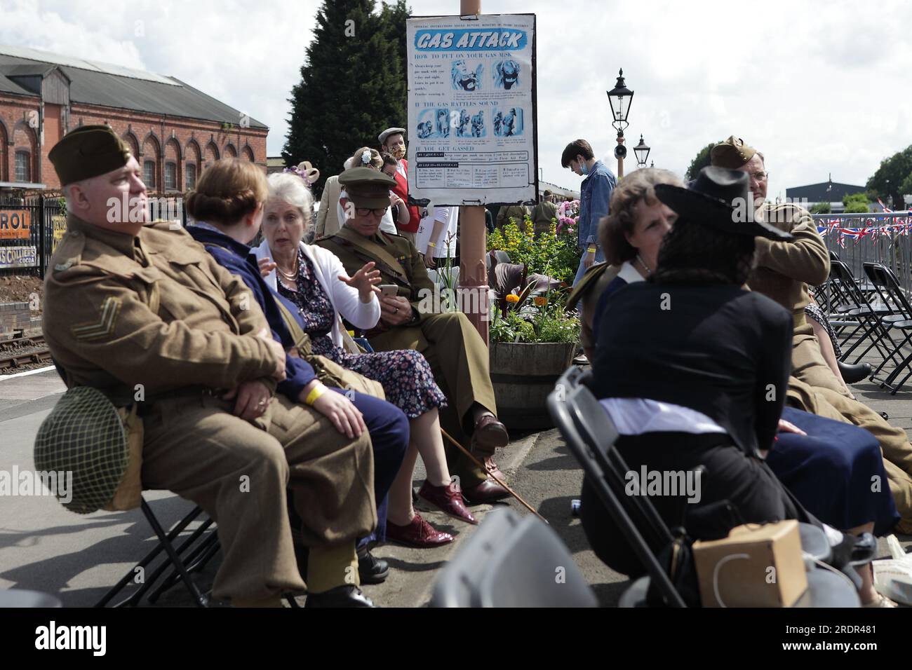1940s enthusiasts seated on the platform of Kidderminster Station during the Severn Valley Railway 1940s day. Stock Photo