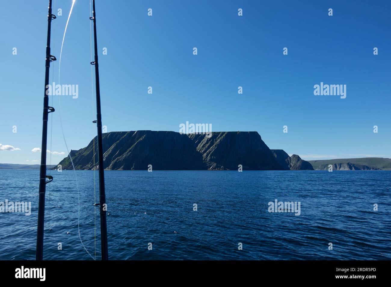 The northernmost tip of Europe large and dramatic rock cliff of North Cape and two fishing rods on summer day on Mageroya island in Finnmark in Northe Stock Photo