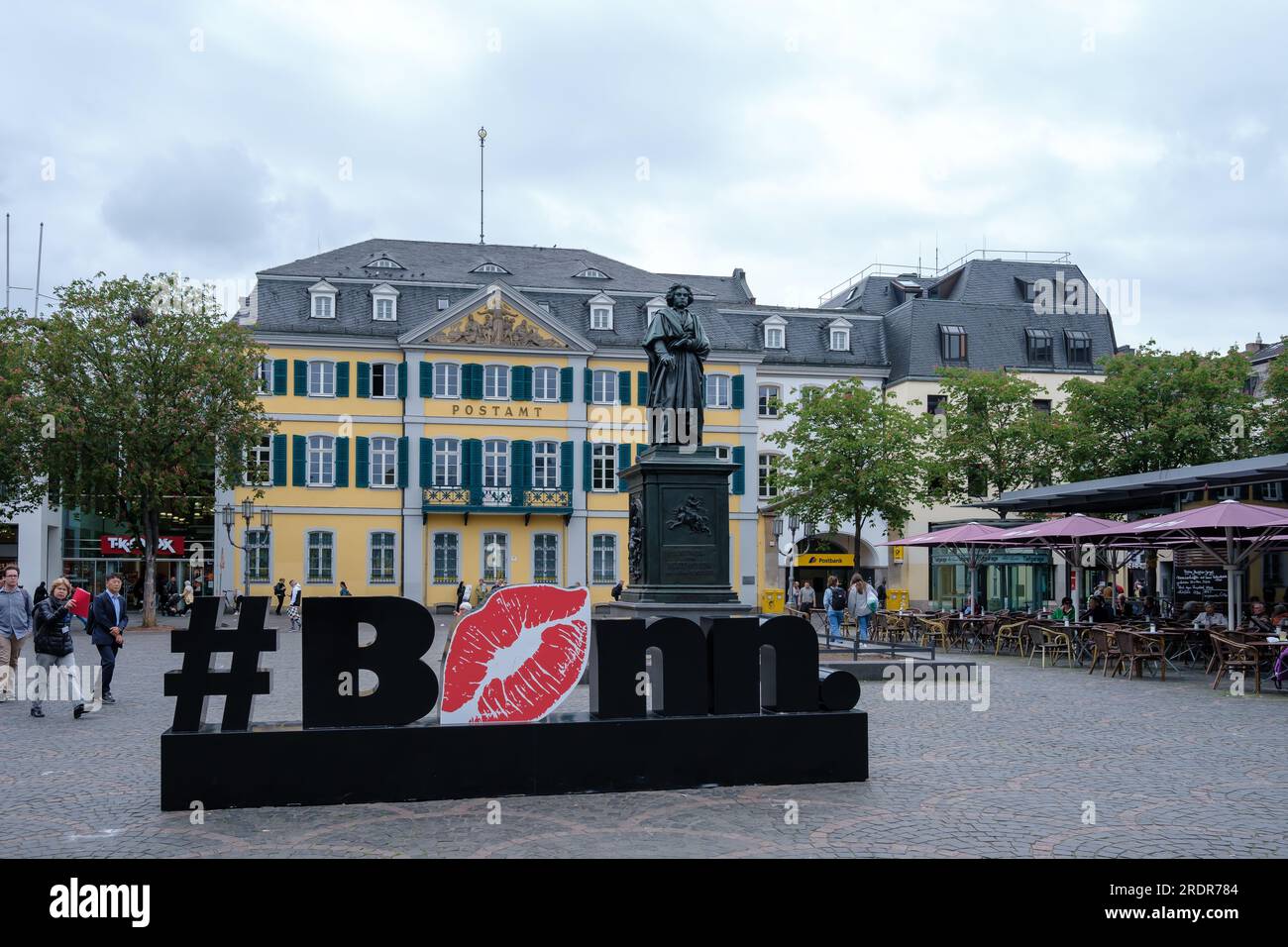 Bonn, Germany - May 22, 2023 : View of the I love Bonn hashtag, the statue of Beethoven, a restaurant and the post office in the center of Bonn German Stock Photo