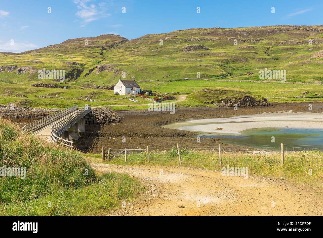 Sanday Bridge which link Canna to Sanday on the Isle of Canna, Small Isles, Scotland with typical croft house, beach and single track, unmade road acr Stock Photo