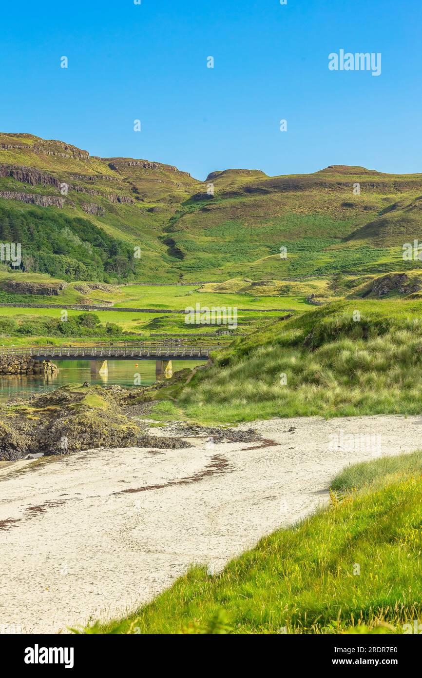 Portrait of Traigh Bhan, the beautiful white beach at Sanday on the Isle of Canna, Hebrides, Scotland with the bridge linking Canna to Sanday.  Vertic Stock Photo
