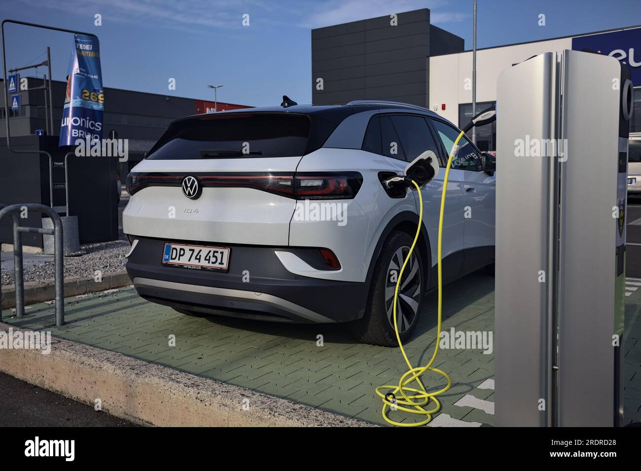 Volkswagen ID4 charging in a parking lot of a mall at sunset Stock
