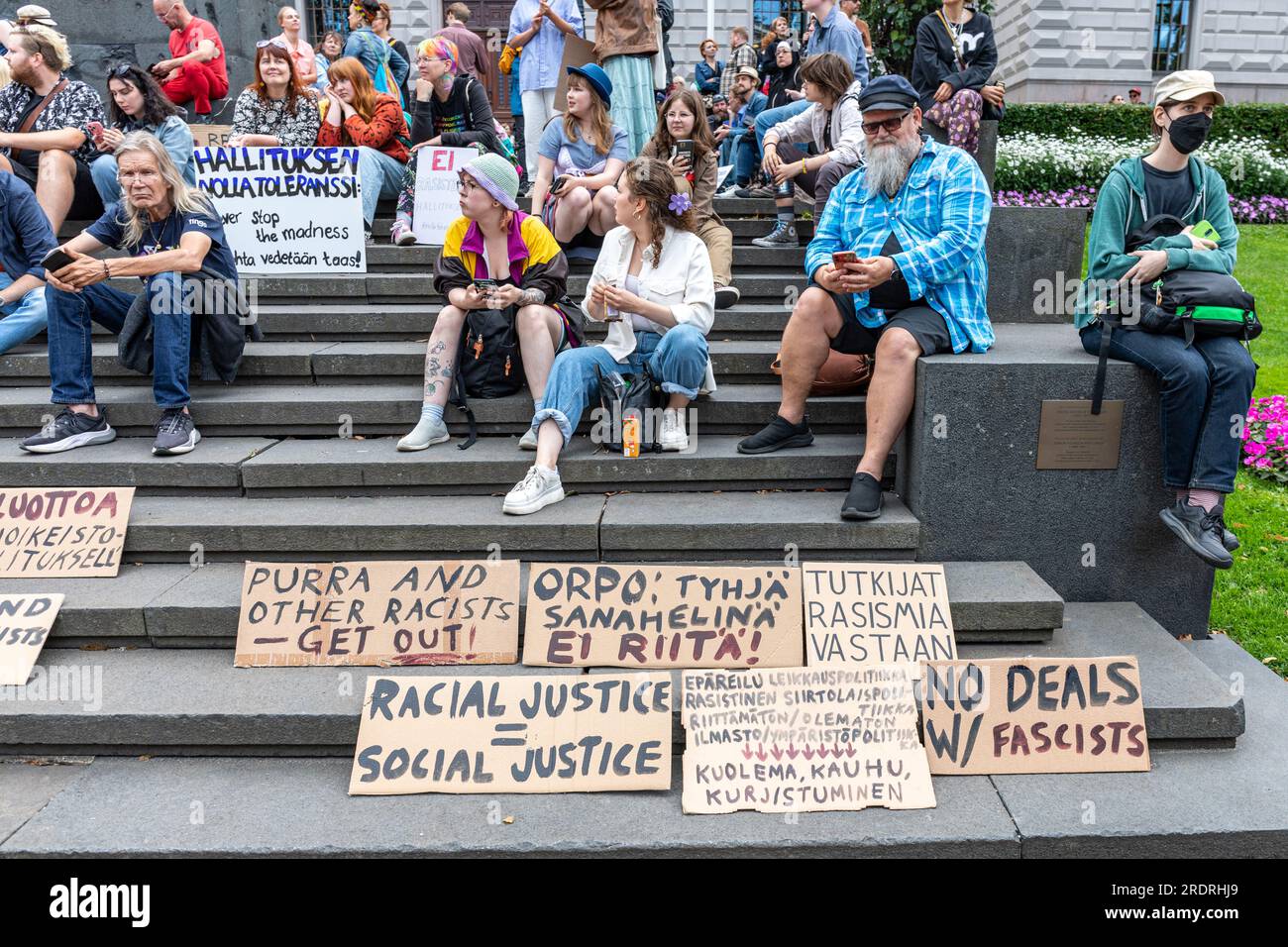 People and cardboard signs on the Bank of Finland steps before Nollatoleranssi! demonstration against far-right politics in Helsinki, Finland Stock Photo
