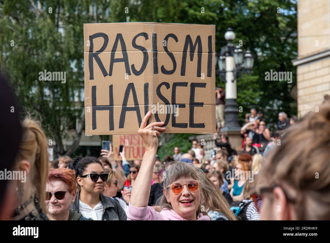 Rasismi haisee. Protester holding a handmade cardboard sign at Nollatoleranssi! Rasistit ulos hallituksesta demonstration in Helsinki, Finland. Stock Photo