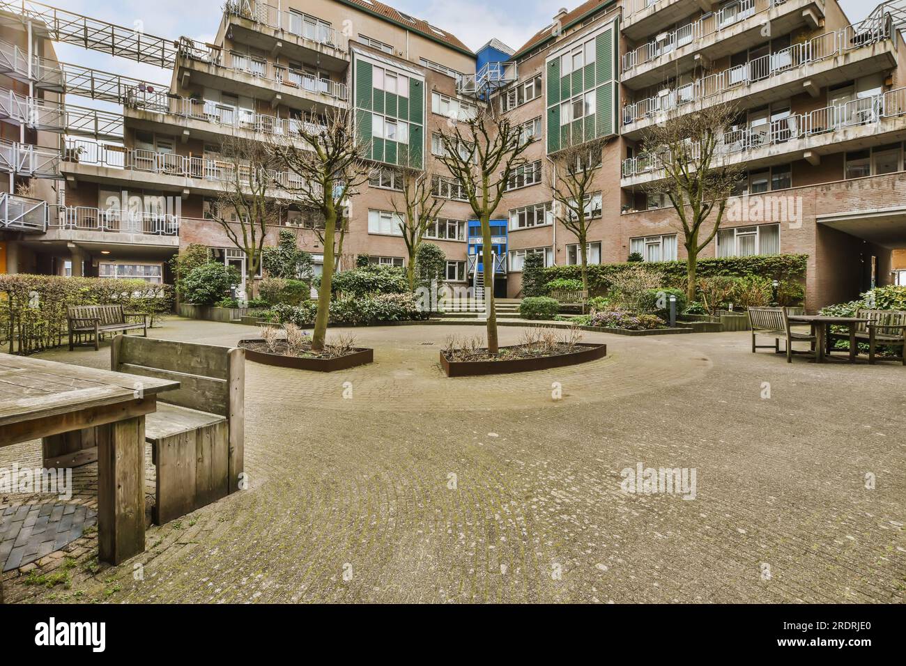 a courtyard with benches and trees in the middle part of an apartment ...