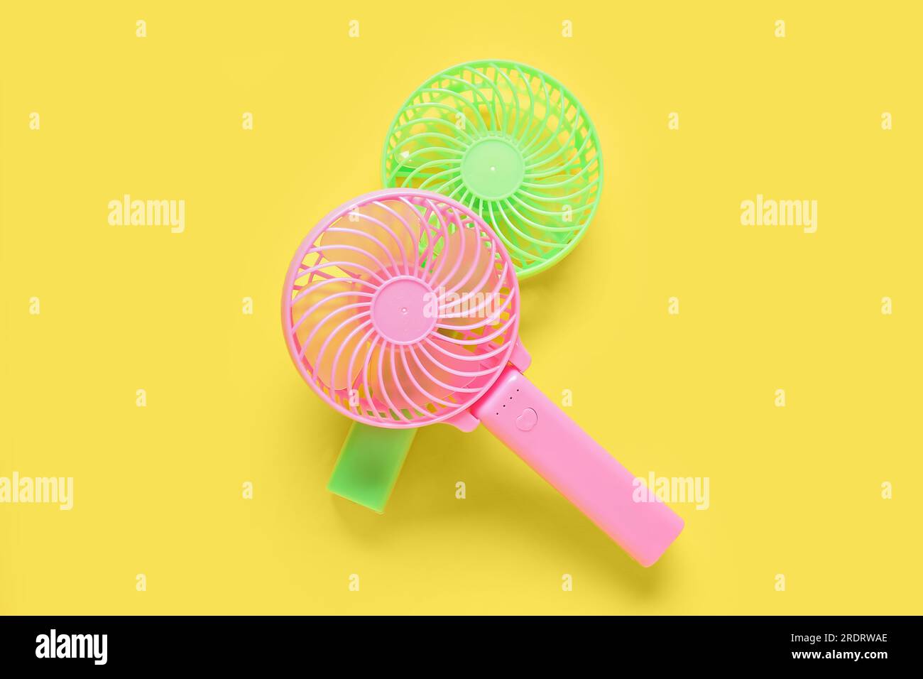 Different manual fans on yellow background Stock Photo Alamy