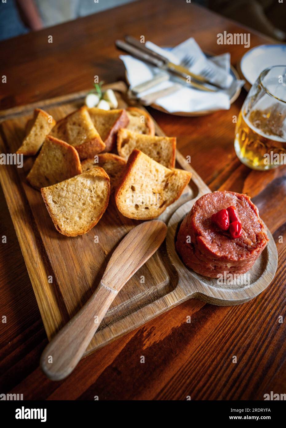 Wooden table with tartar steak and toasts on table and beer. Stock Photo