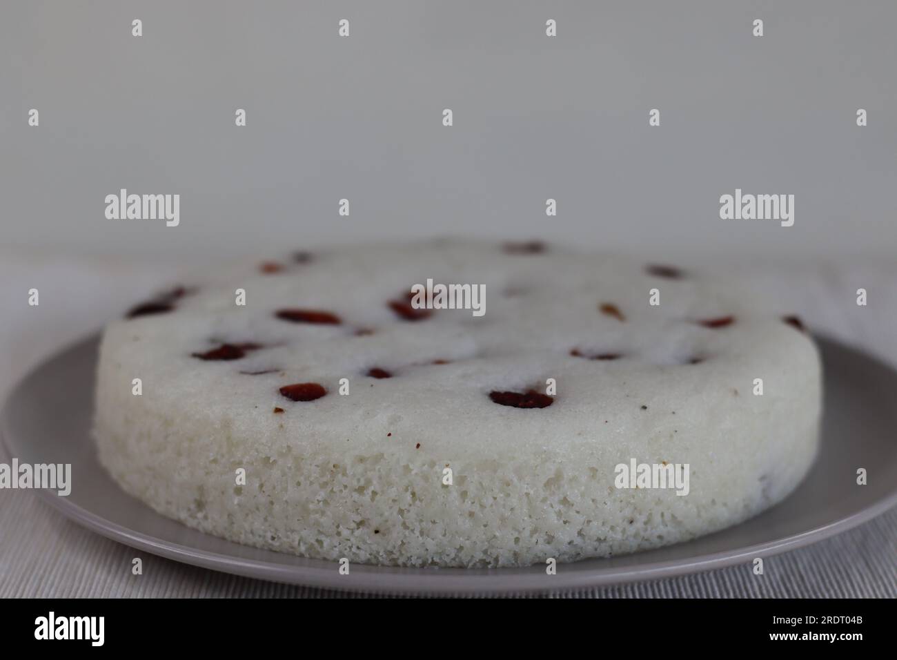 Vattayappam. Steamed spongy rice cake topped with dried cranberries. A