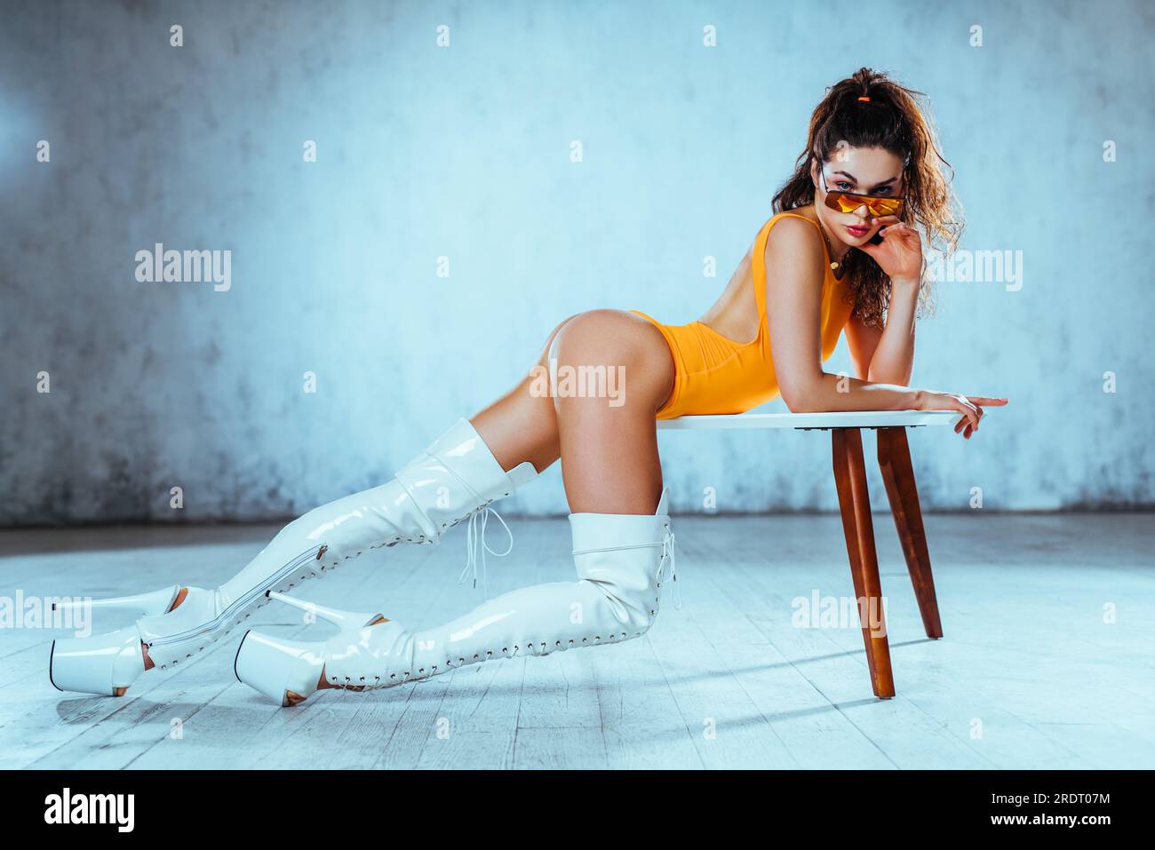 Young woman dancer posing in bright white interior with table Stock Photo