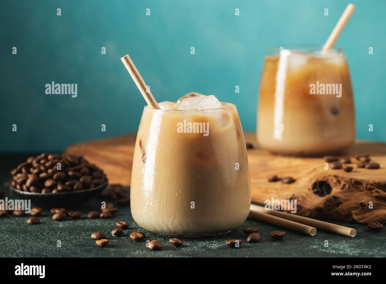 https://c8.alamy.com/comp/2RDT4K3/ice-coffee-in-a-tall-glass-with-cream-poured-over-ice-cubes-and-beans-on-a-dark-concrete-table-2RDT4K3.jpg