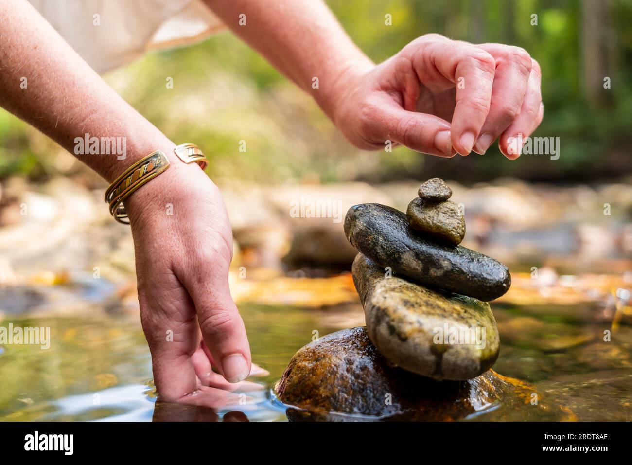 Stones arranged in zen towers by the river bed on a summers day Stock Photo
