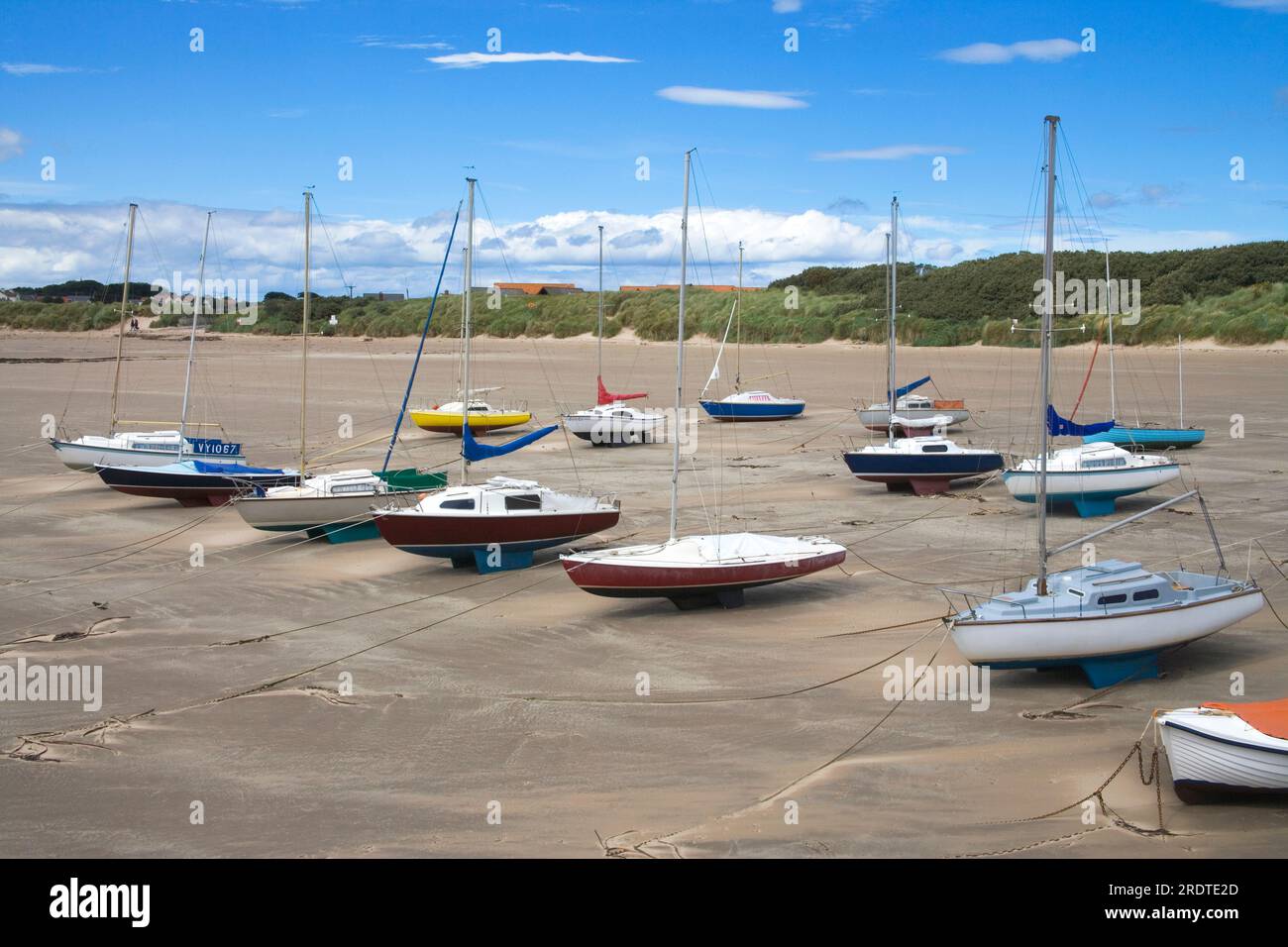 yachts moored at low tide in beadnell bay northumberland Stock Photo