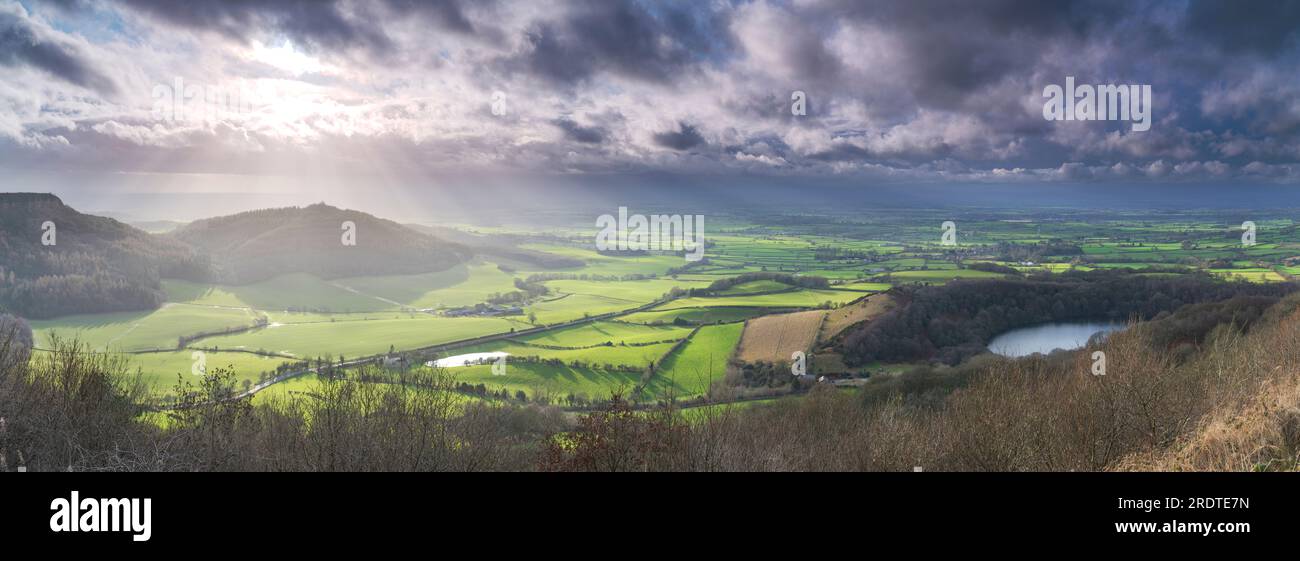 Panoramic view of Roulston Scar, Hood Hill, Lake Gormire and the Vale of Mowbray under storm clouds. Stock Photo