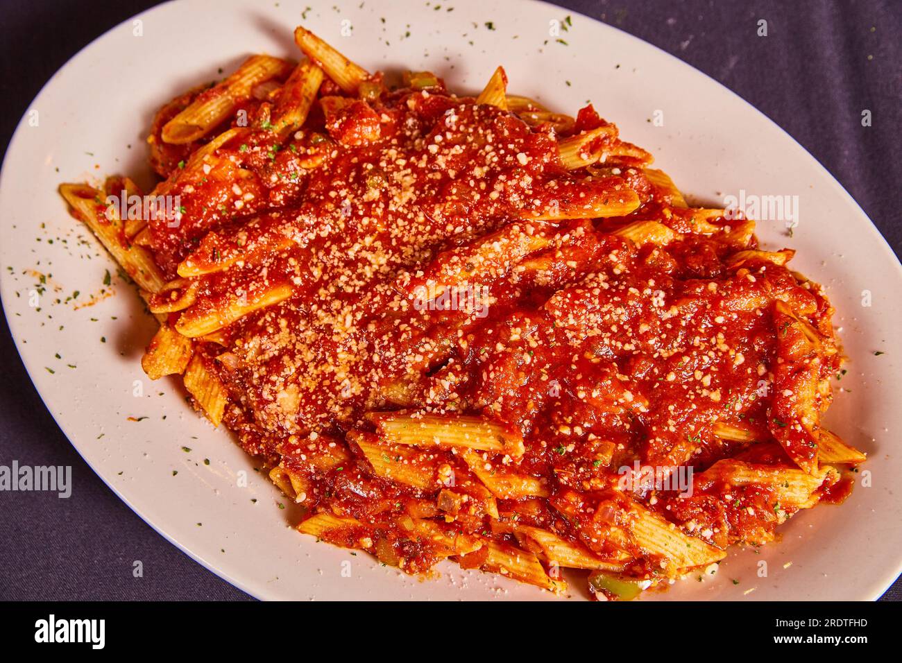 White plate of Fontanini sausage lunch special meal Italian red pasta sauce noodles parsley flakes Stock Photo