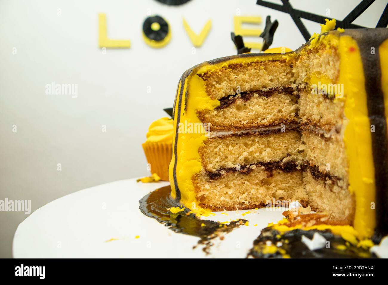 Cake with yellow frosting on top and the word love. Stock Photo