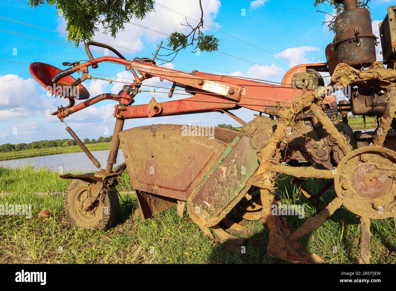 Old rusty tractor on the field with blue sky background Stock Photo - Alamy
