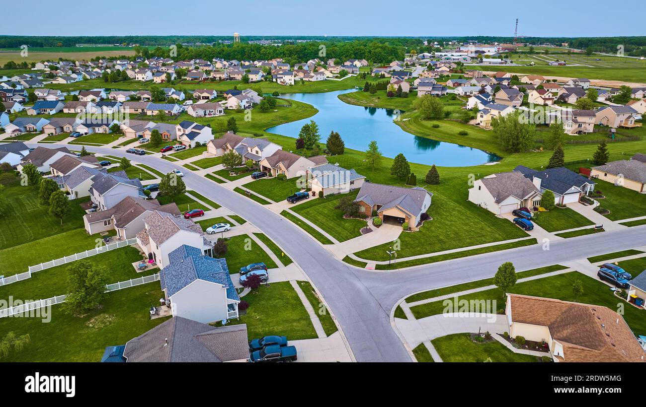 Large pond surrounded by suburban neighborhood HOA houses white picket
