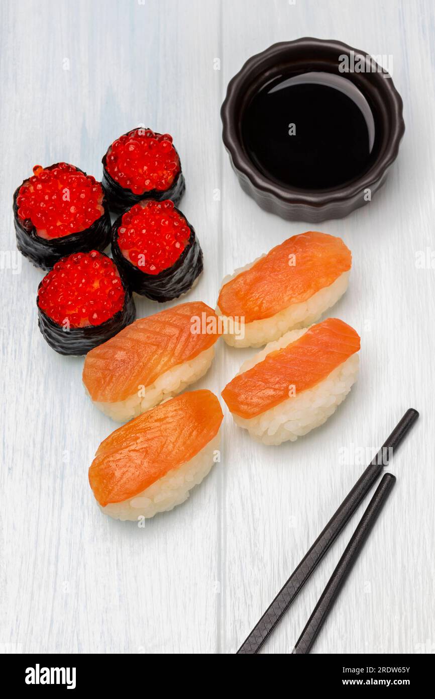Sushi with caviar and salmon and soy sauce in a bowl, chopsticks. Top