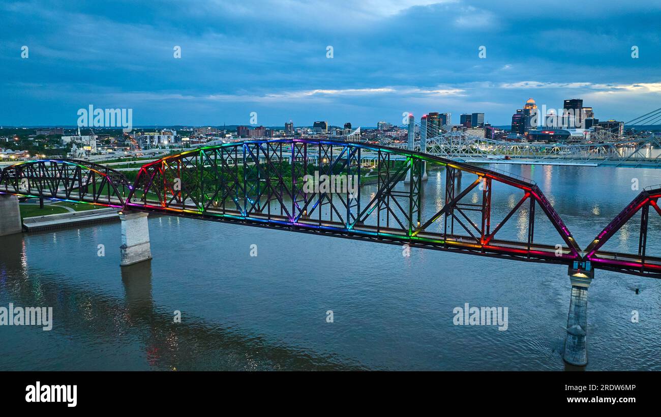 Arch bridge aerial rainbow pride illuminated at night over Ohio River Louisville Kentucky Stock Photo