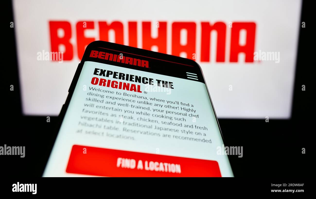 Mobile phone with website of US restaurant company Benihana Inc. on screen in front of business logo. Focus on top-left of phone display. Stock Photo