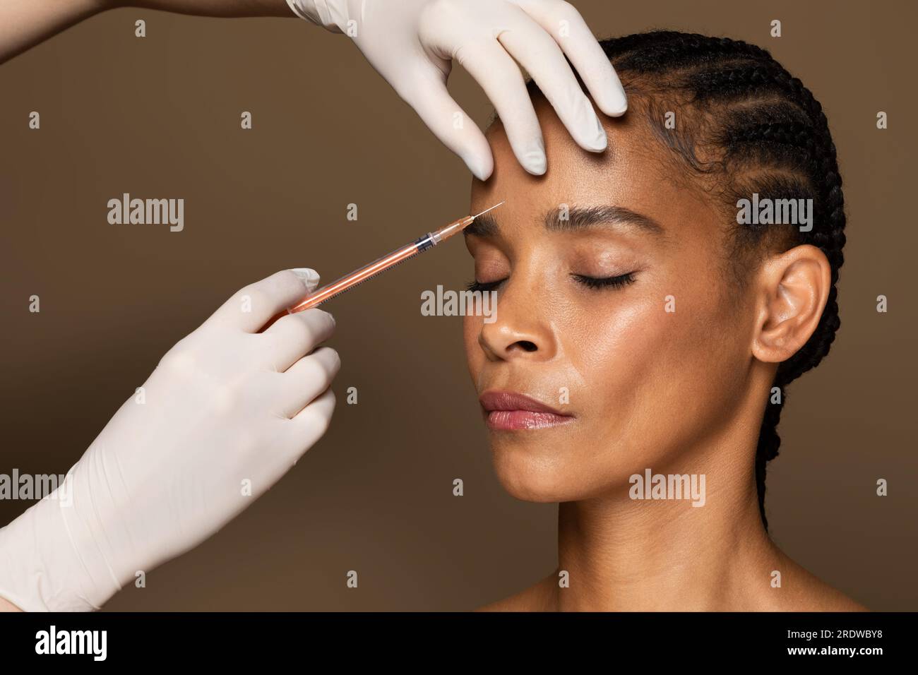 Beautician hands making hyaluronic acid injection, black middle aged