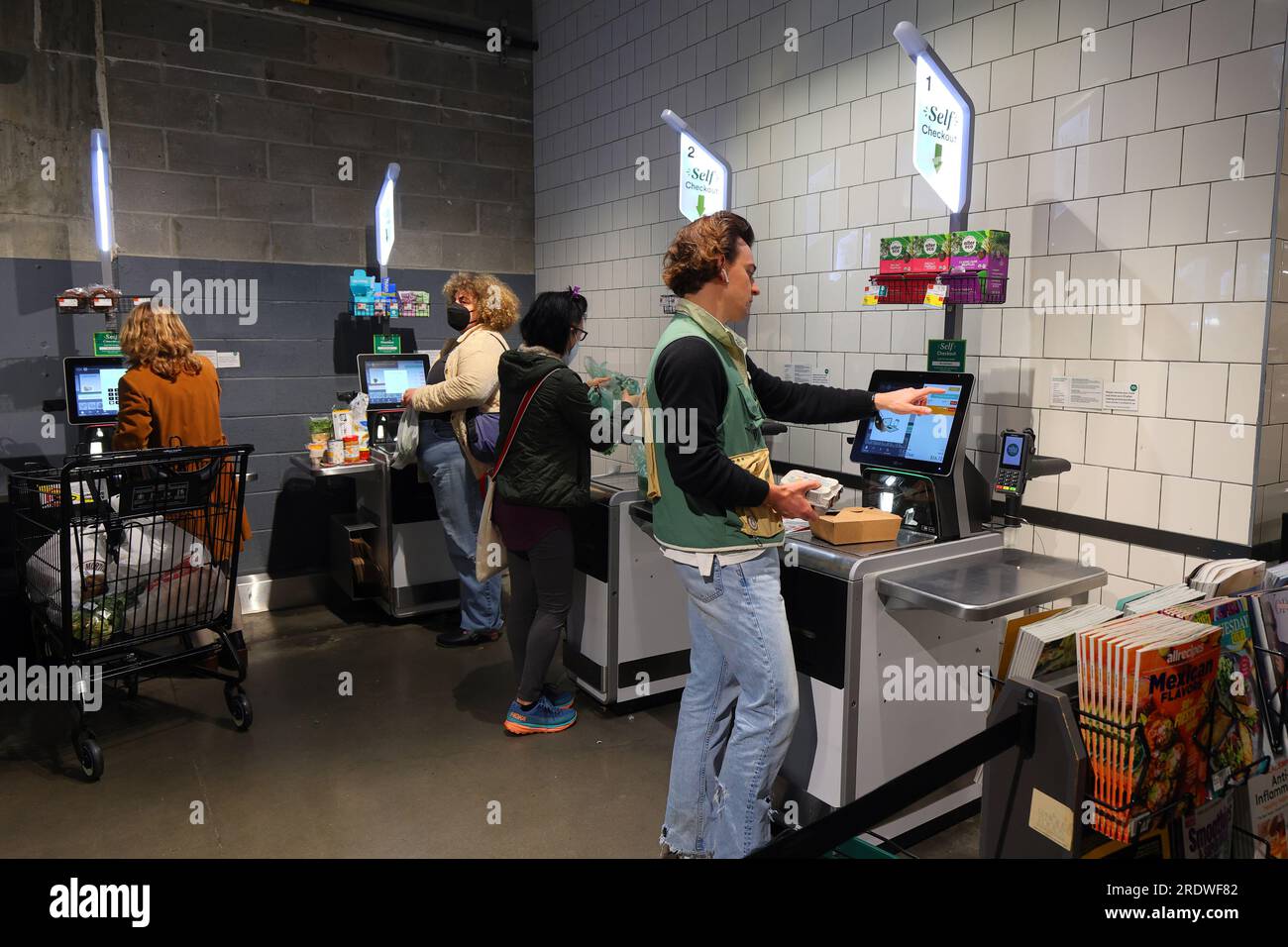 People at a self service, self-checkout till in a supermarket. Stock Photo