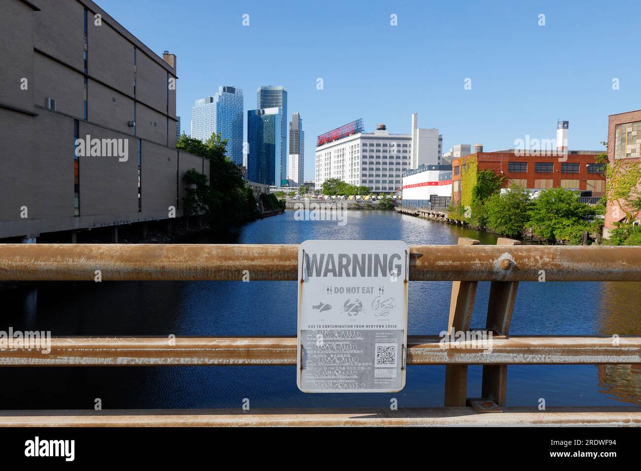 A view of Dutch Kills--a section of Newtown Creek, New York City--with signage warning against eating fish and shellfish from the tidal estuary. Stock Photo