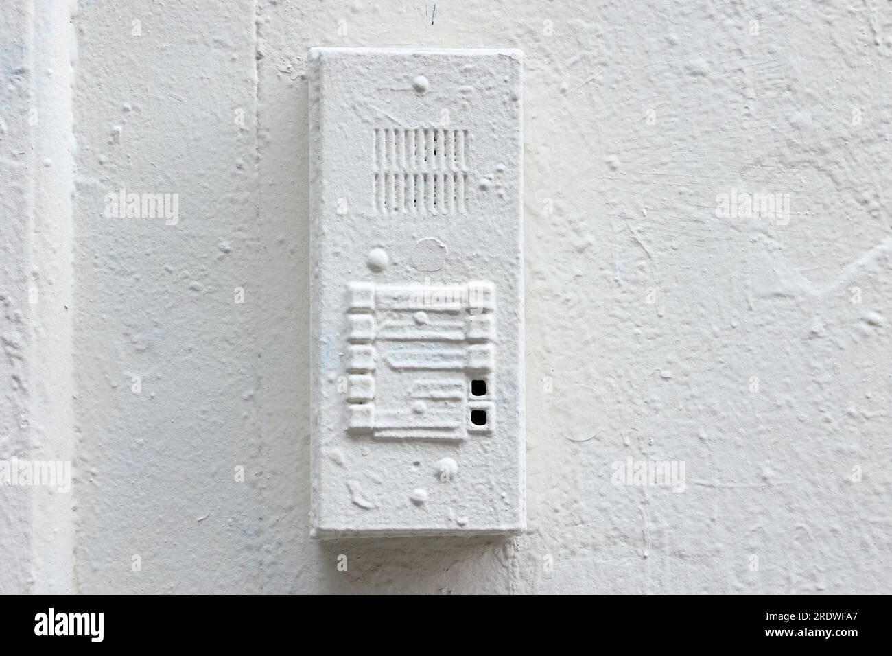 A Landlord Special. An intercom system painted over with multiple layers of cheap white paint. Stock Photo