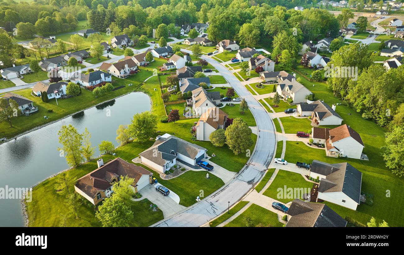 Aerial houses around pond in neighborhood suburban with distant housing ...