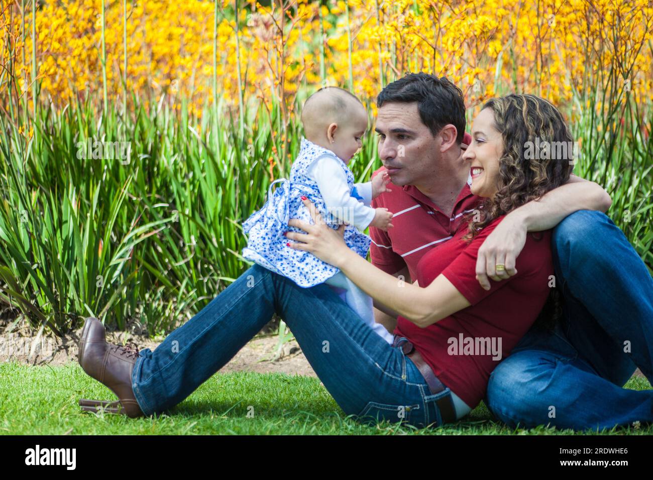 Young parents having fun outdoors with their six months old baby girl. Happiness concept. Family