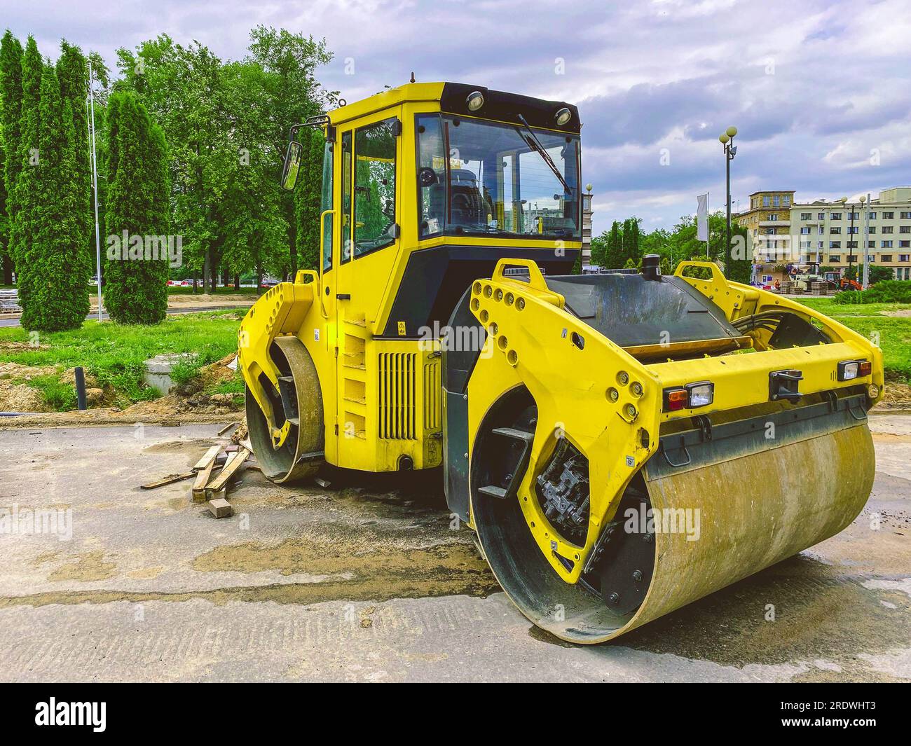 construction equipment lays communications. bright, yellow asphalt ...
