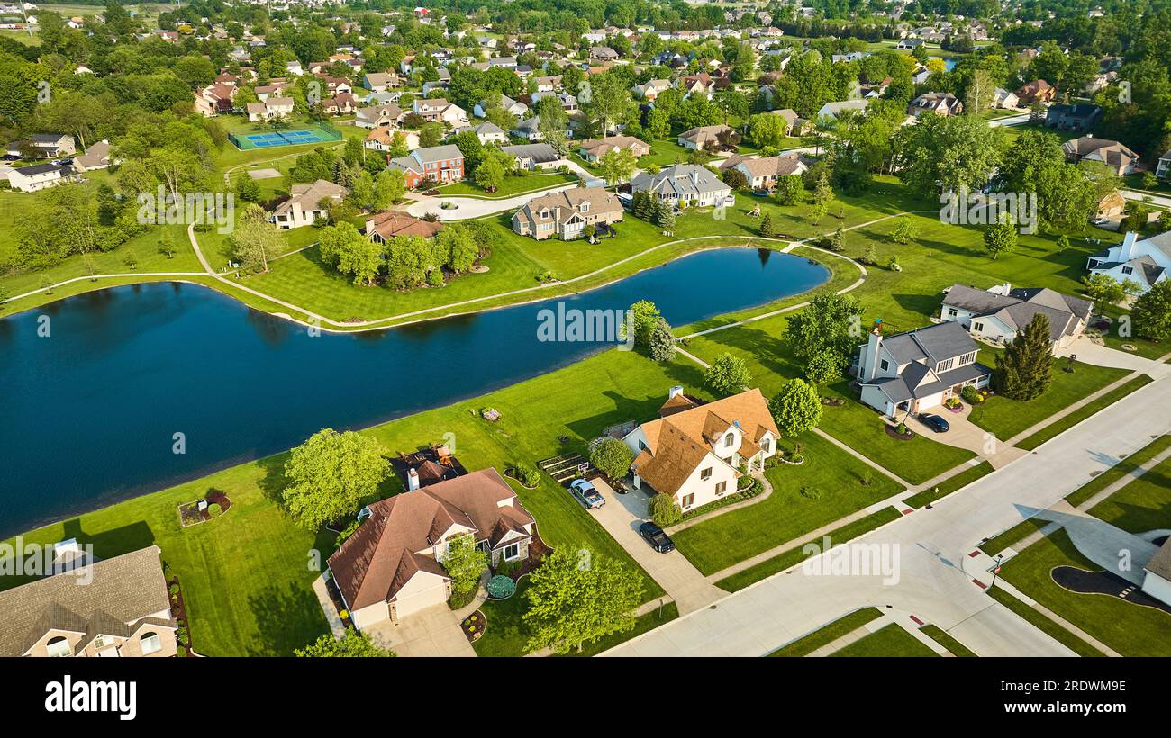 Pond in middleclass neighborhood with tennis court amenity aerial of