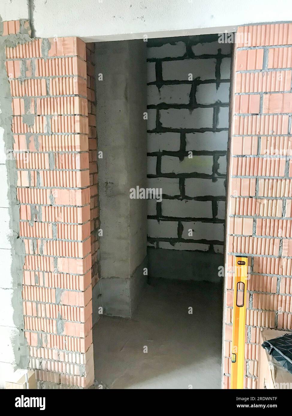 The doorway in the new building with a free plan, in an apartment without repair with walls of red brick and gas silicate blocks. Stock Photo