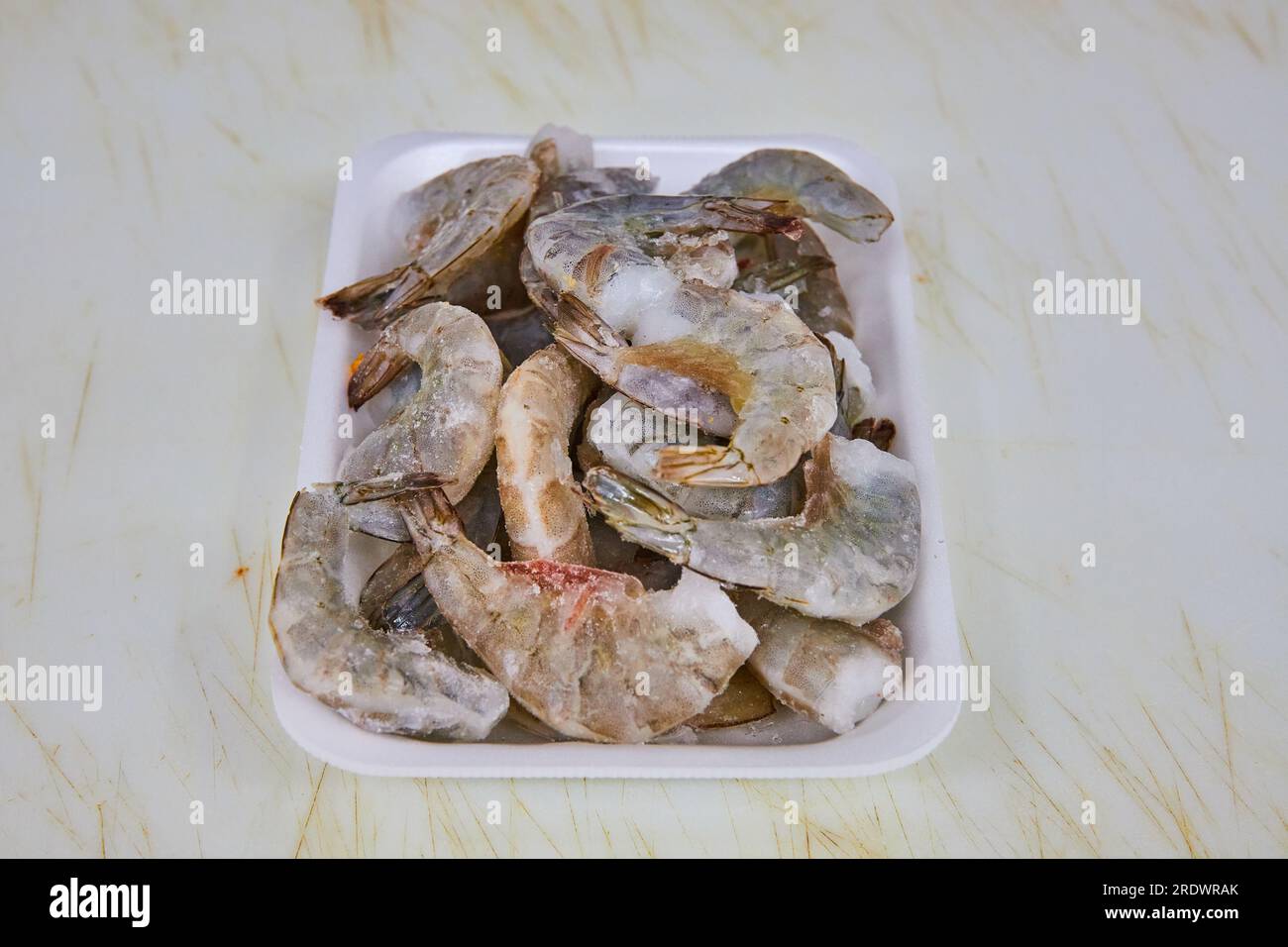 Pile raw shrimp, seafood on white tray, grocery store, meat department Stock Photo