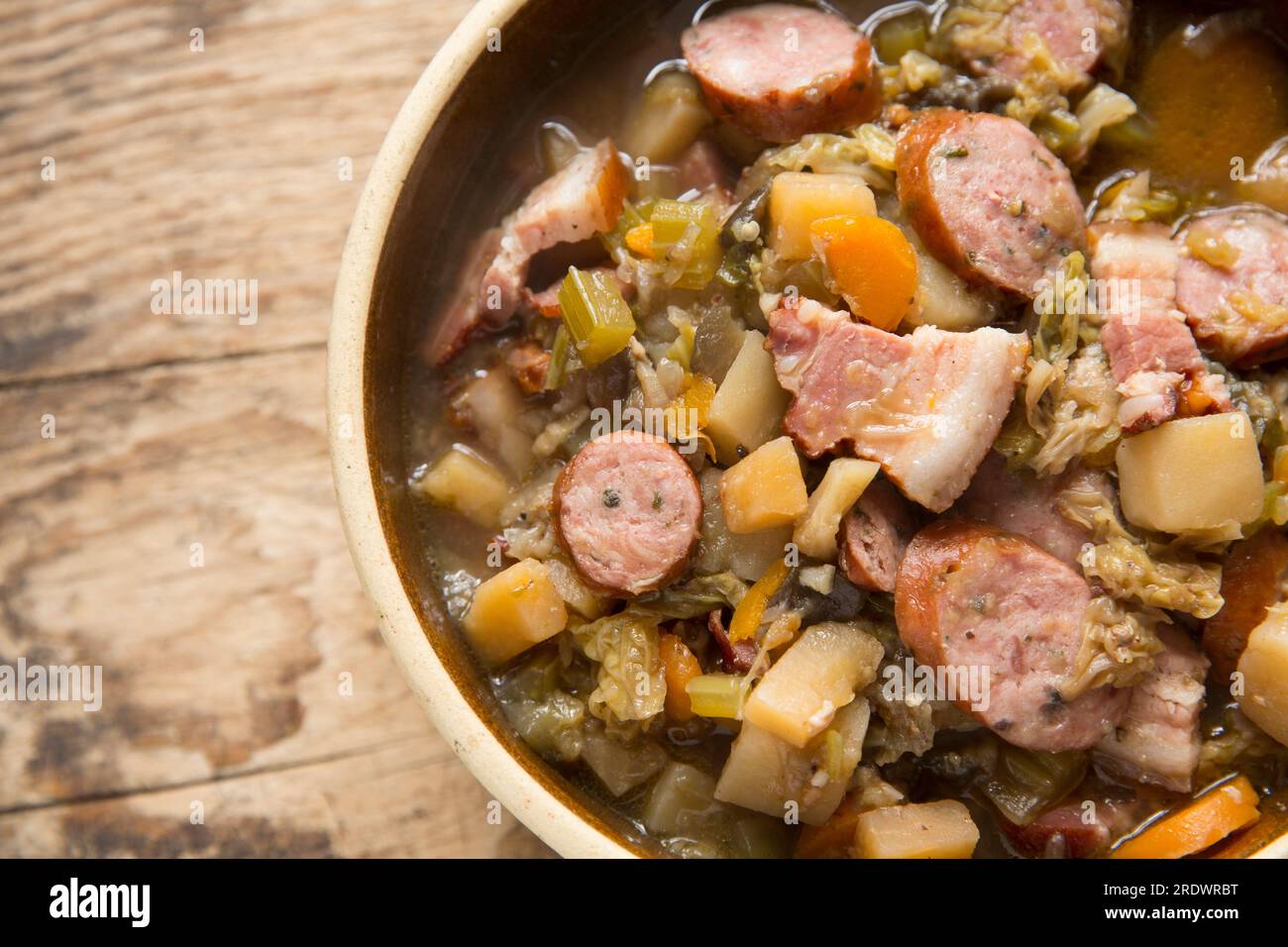 A homemade eintopf made in a slow cooker with largely root vegetables and cabbage with herbed Polish pork sausage and smoked bacon. England U Stock Photo
