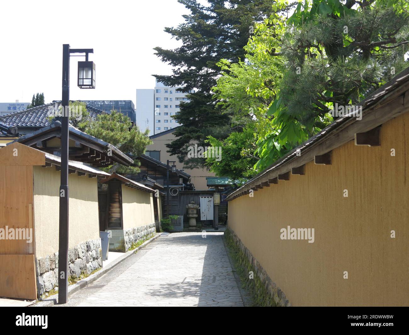 High yellow earthen walls with small doorways characterise the district of Nagamachi in Kanazawa, an historic area where the Samurai class lived. Stock Photo