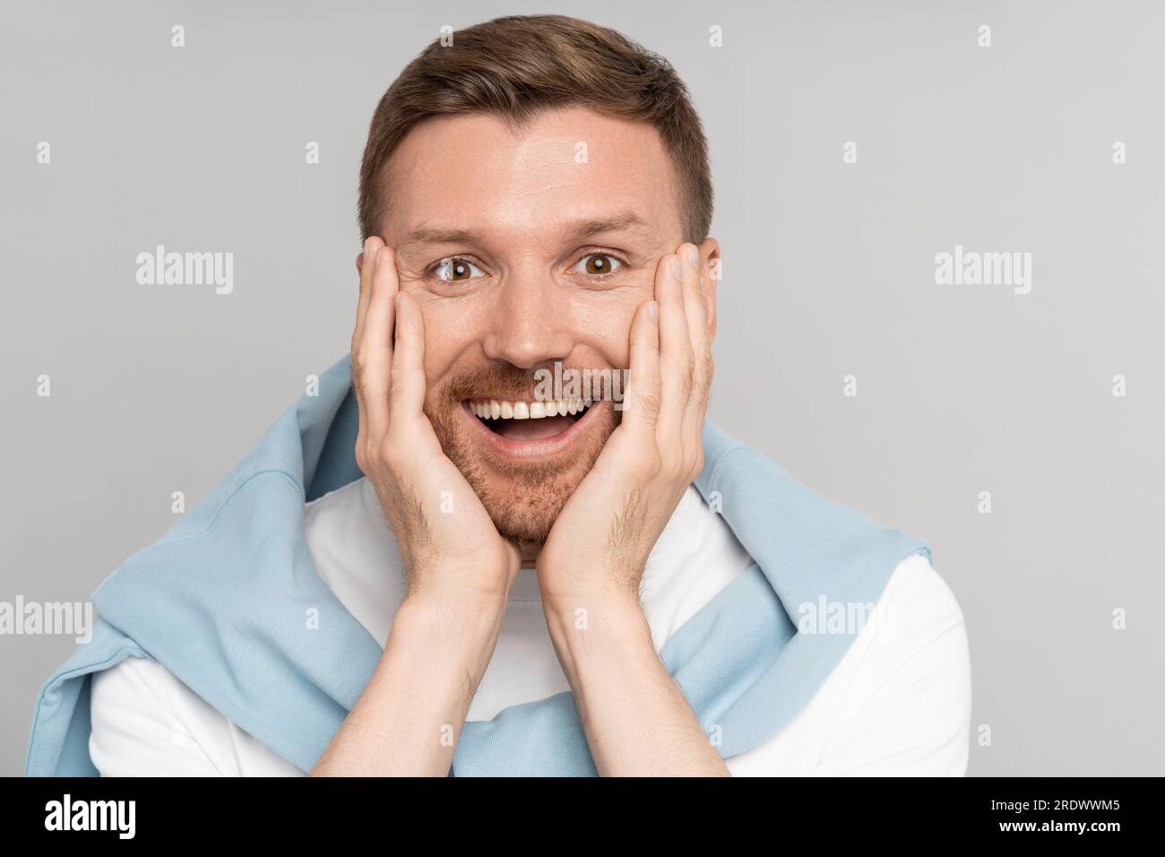 Smiling handsome man with mouth open. Excited guy getting amazed of positive news. Closeup face.  Stock Photo