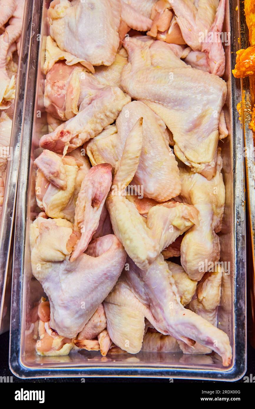 Container raw chicken wings, poultry, uncooked, meat department