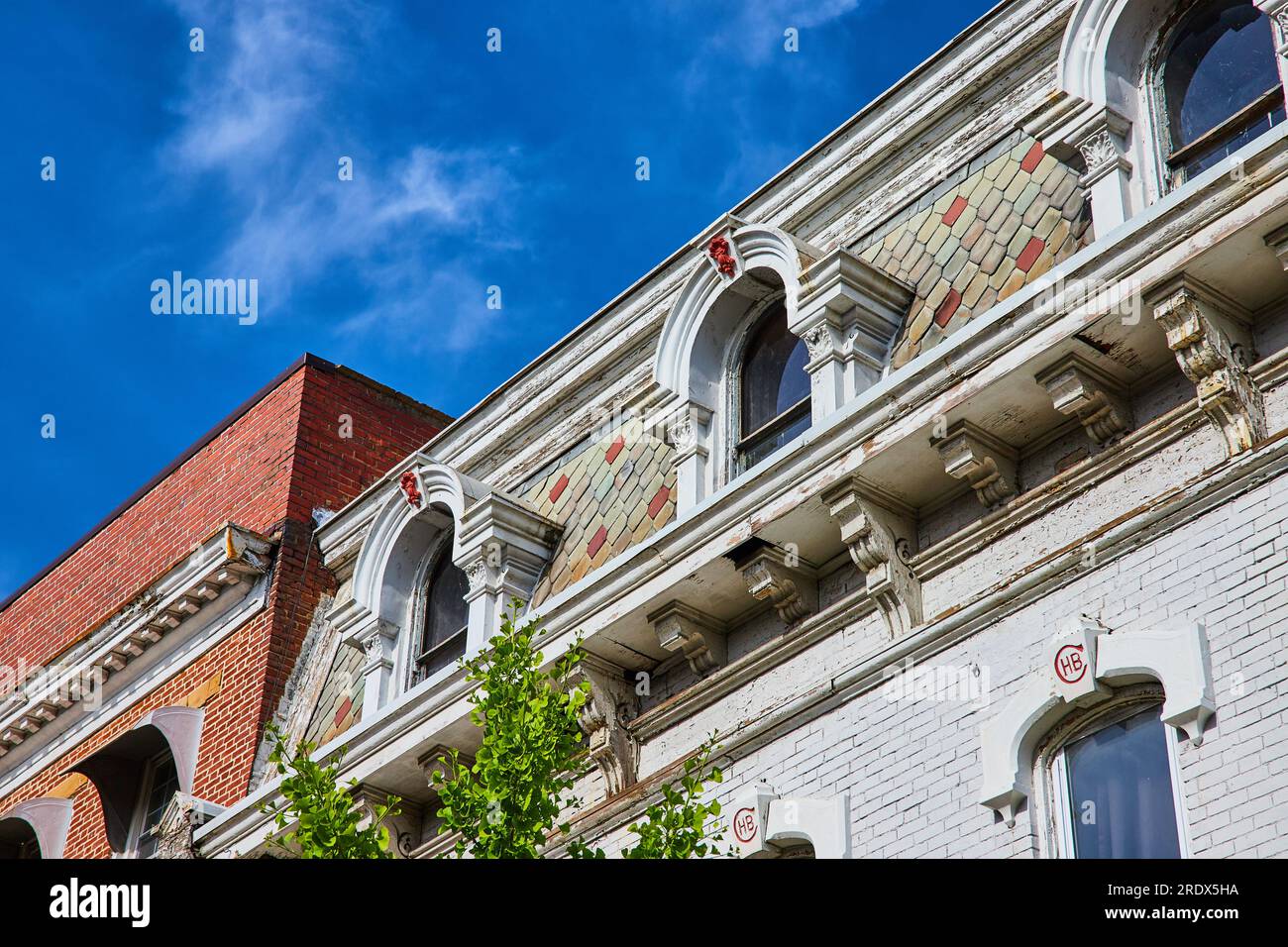 Upward view of unique white brick building with colorful tile siding