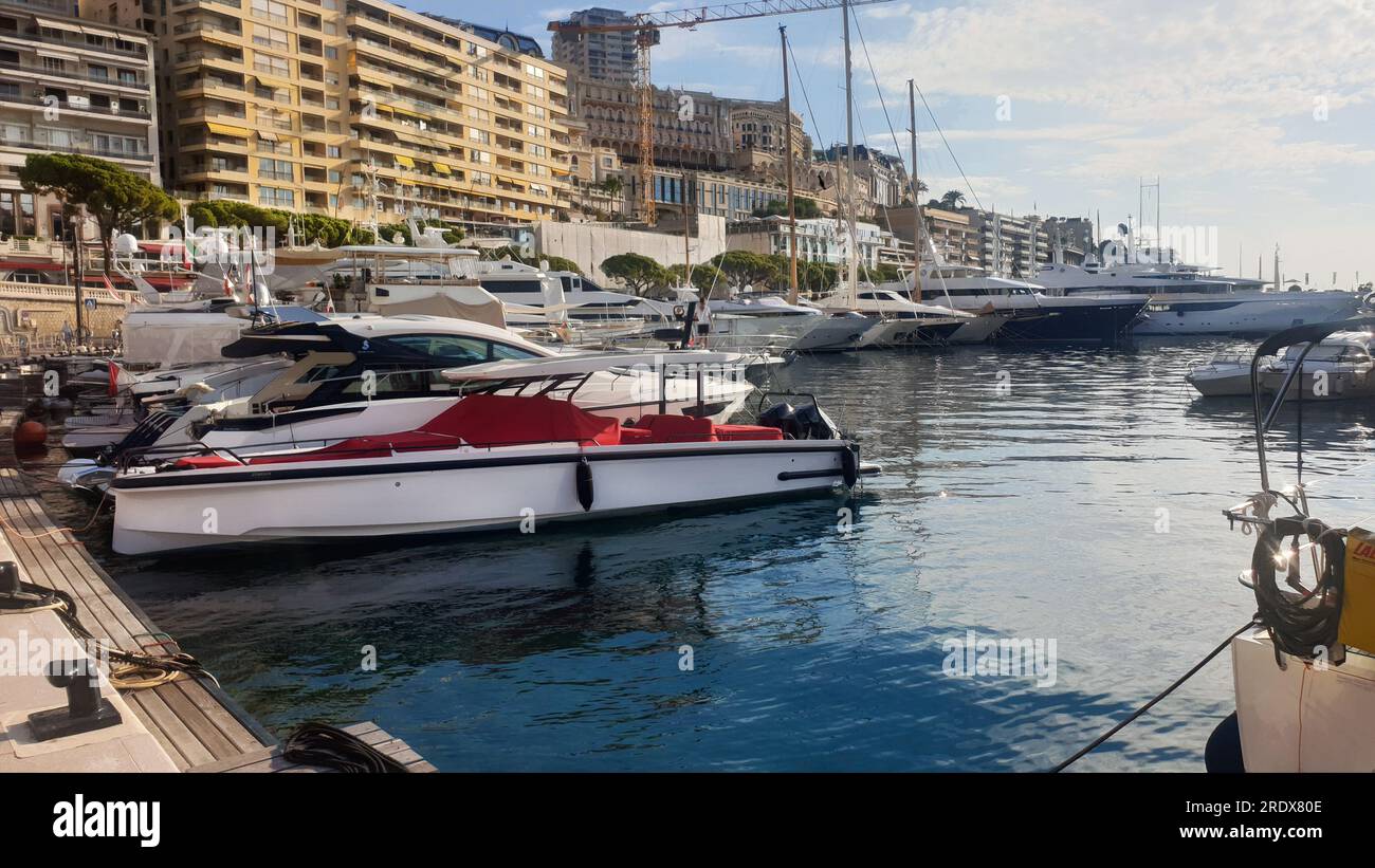 Fantastic morning  view on yachts  (pleasure boat) in port Hercule of Monaco and reflections in water. Above  buildings of  Monte Carlo district  incl Stock Photo